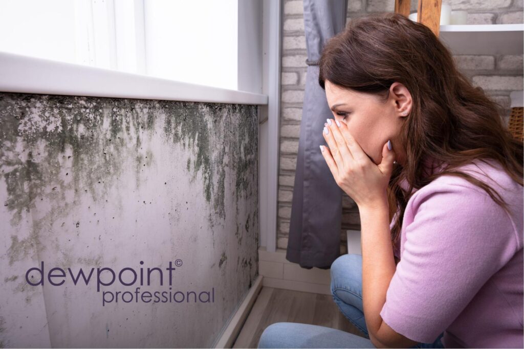 Woman looking at mould on a wall.